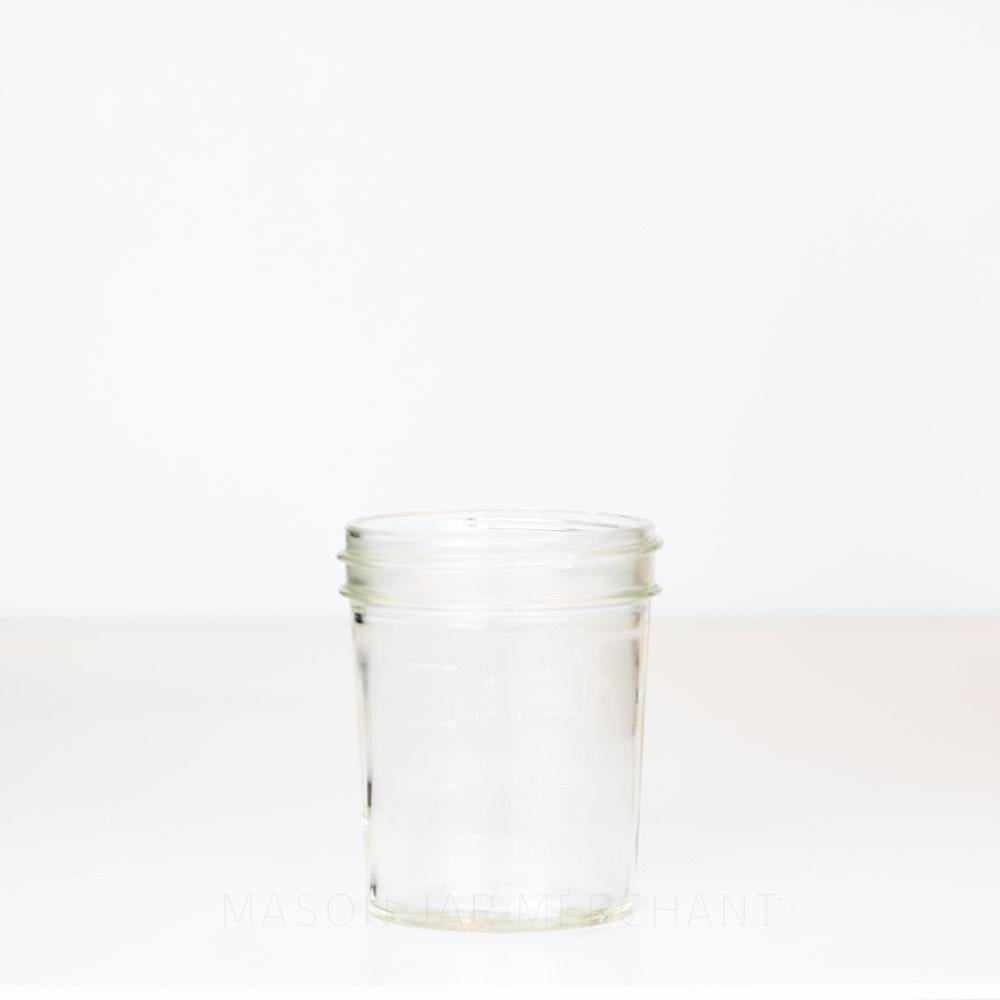 Wide mouth half pint mason jar with straight sides and measurement markings against a white background 