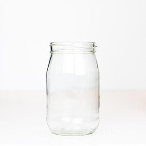 Wide mouth quart mason jar with no markings and smooth sides, on a white background 