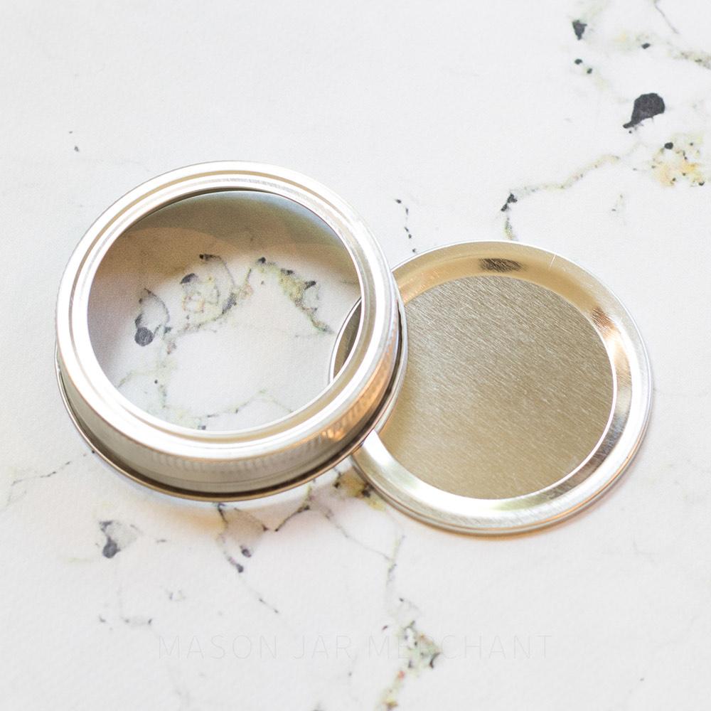 Plain Silver Regular Mouth (Standard) Mason Jar Lid, shown on a marble background.