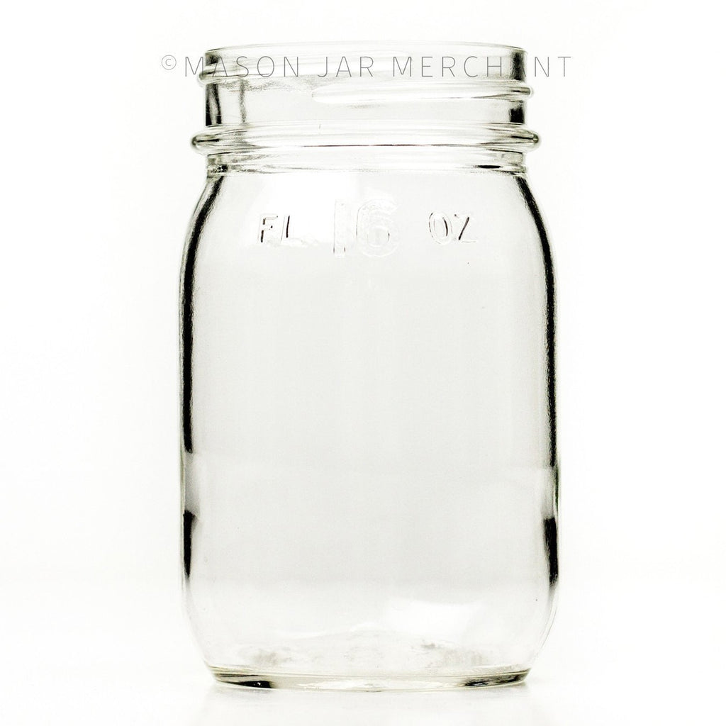 Vintage regular mouth pint mason jar with FL 16 oz imprinted near the rim, against a white background 